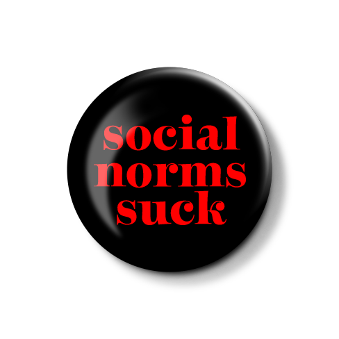 Runde Badge-Buttons mit dem Aufdruck "social norms suck" in roten Buchstaben auf schwarzem Hintergrund.