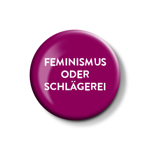 Lila Anstecknadel mit dem Aufdruck „FEMINISMUS ODER SCHLÄGEREI“.