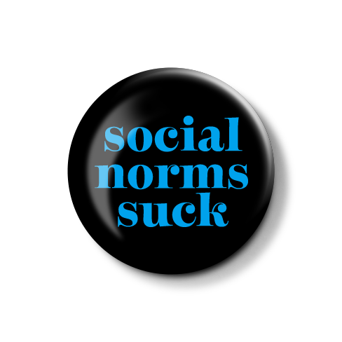 Runder Anstecker mit der Aufschrift "social norms suck" in blauer Schrift auf schwarzem Hintergrund.