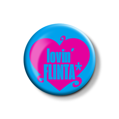 Bunte Anstecknadel mit einem Herzmotiv und dem Text "lovin' FLINTA*" in pink und blau.